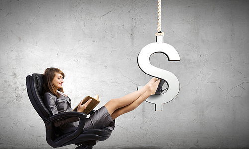 Young attractive businesswoman sitting in chair and reading book