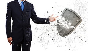 Businessman breaking stone shield with finger touch