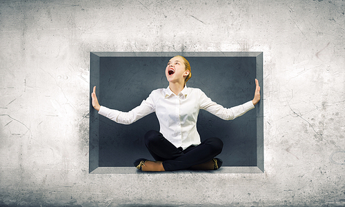 Young woman trapped in stone cube in wall