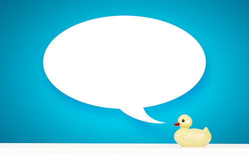 Yellow rubber duck toy on table with speech bubble