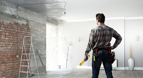 Builder man in checked shirt with tool belt on waist