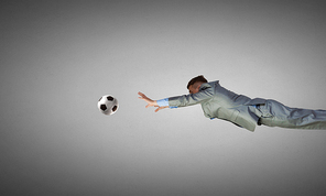 Businessman in suit catching soccer ball in jump
