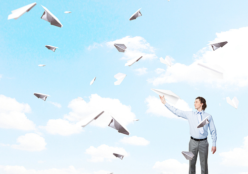 Young businessman with paper plane in hand