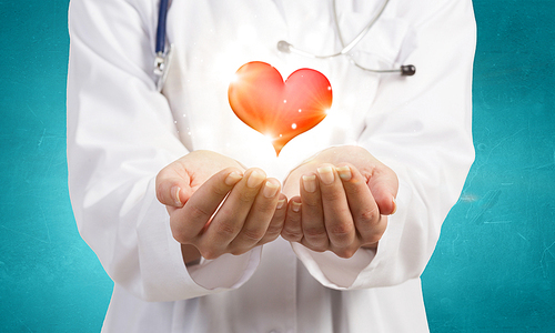 Close up of female doctor holding heart in hands