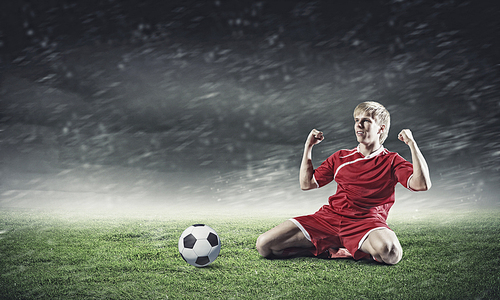 Football player standing on knees and screaming with joy