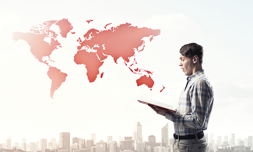 Young businessman with opened book in hands and world map on background