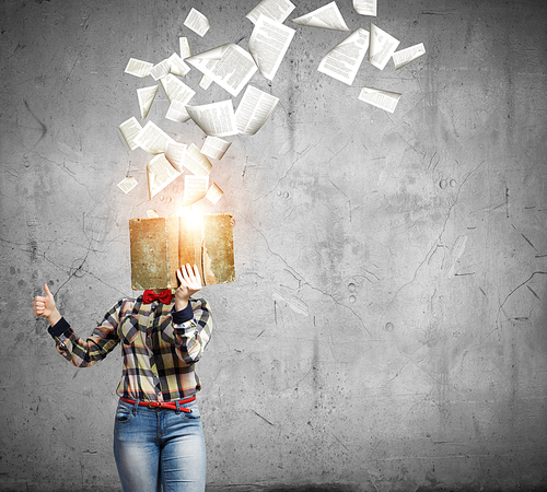 Woman in casual wear hiding her face behind book