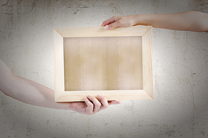 Close up of hands holding wooden blank frame. Place for text