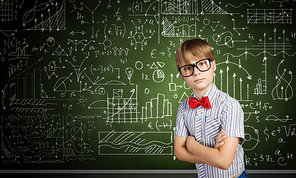 Genius boy in red glasses near blackboard with formulas