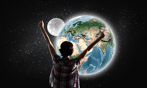 Back view of girl with hands up looking at planets. Elements of this image are furnished by NASA