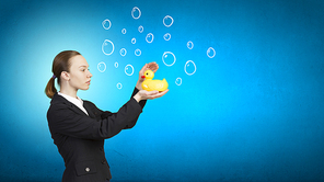 Young businesswoman with yellow rubber duck toy