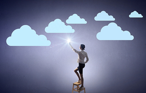 Businesswoman standing on chair and reaching cloud in sky