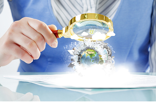 Close view of businesswoman examining Earth planet with magnifying glass. Elements of this image are furnished by NASA