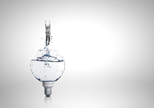 Conceptual image with light bulb filled with clear water and businessman inside