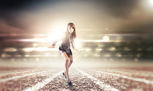 Young businesswoman in suit running on stadium track