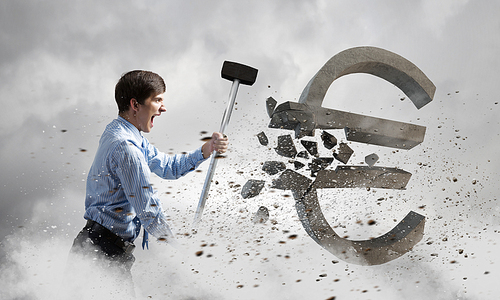 Young businessman crashing with hammer stone euro symbol