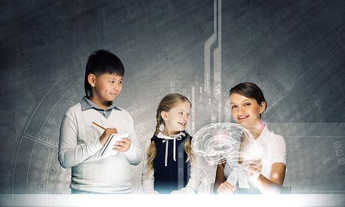 Young teacher and her pupils examining hologram of human brain