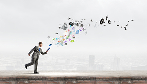 Young businessman running with opened book in hand