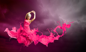 Young attractive woman in pink dress jumping high