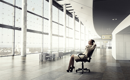 Young relaxed businesswoman sitting relaxed in chair in office