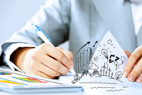 Image of businesswoman sitting at table and drawing sketch