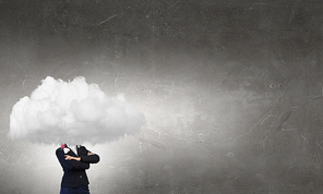 Businesswoman in suit standing with her head in cloud