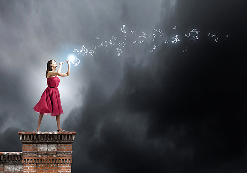 Young woman in red dress on building top playing fife