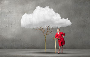 Blond woman in red coat with axe and green tree
