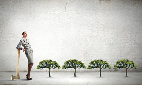 Young businesswoman with axe and green tree