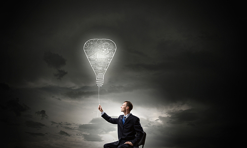 Businessman with bulb on rope representing bright idea