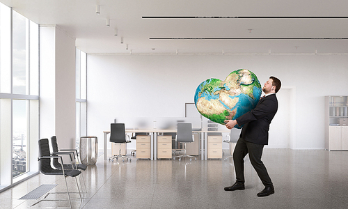 Businessman holding world in his hands. Elements of this image are furnished by NASA