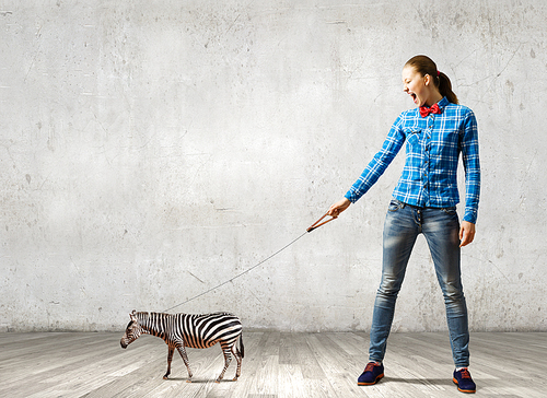 Young woman in casual holding zebra on lead