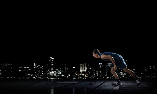 Running man in blue sport wear on black background