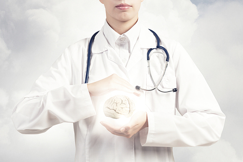 Close up of female doctor with stethoscope and brain in hands
