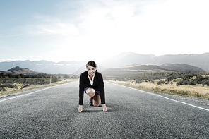 Young determined businesswoman standing in start position ready to compete