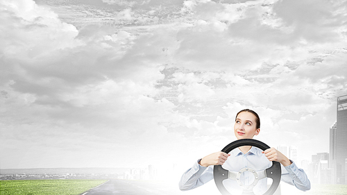 Young smiling pretty woman driving steering wheel