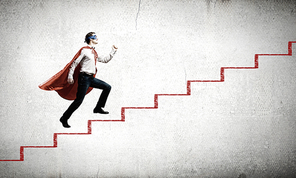 Young superman walking up the stair case