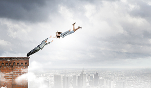 Two young business people flying in sky