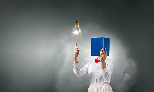 Unrecognizable woman with opened book against her face