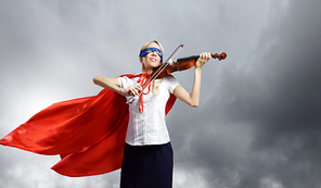 Young woman in super hero costume playing violin