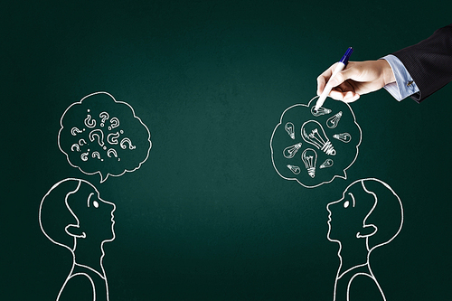 Close up of hand drawing dialogue between two on blackboard