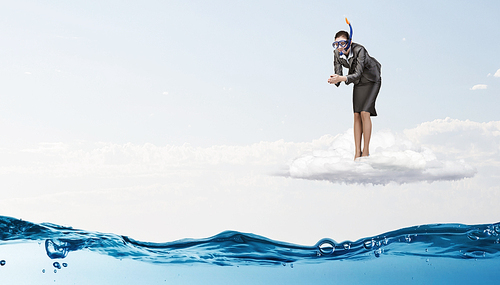 Young businesswoman in suit and diving mask jumping in water