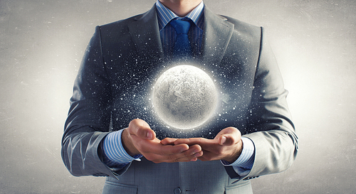 Close up of businessman holding moon planet in palms