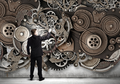 Young businessman fixing gears mechanism with wrench