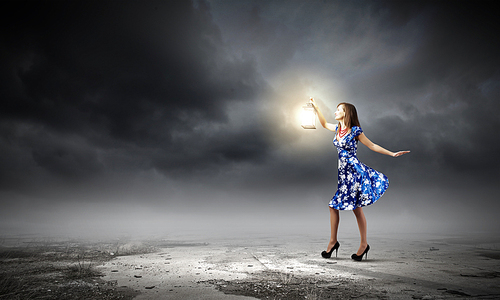 Young woman in blue dress with lantern