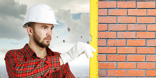 Builder man in checked shirt using measuring level