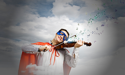 Young man in superhero costume playing violin