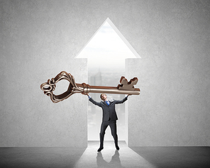 Young businessman and lifting big key above head