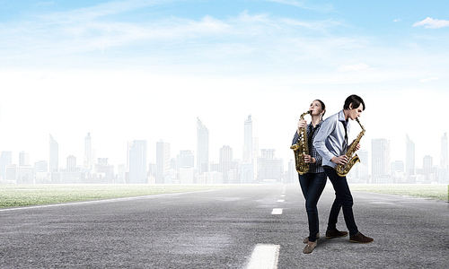 Duet of young man and woman musicians playing saxophones