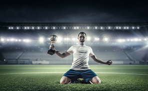 Soccer player celebrating victory while holding win cup